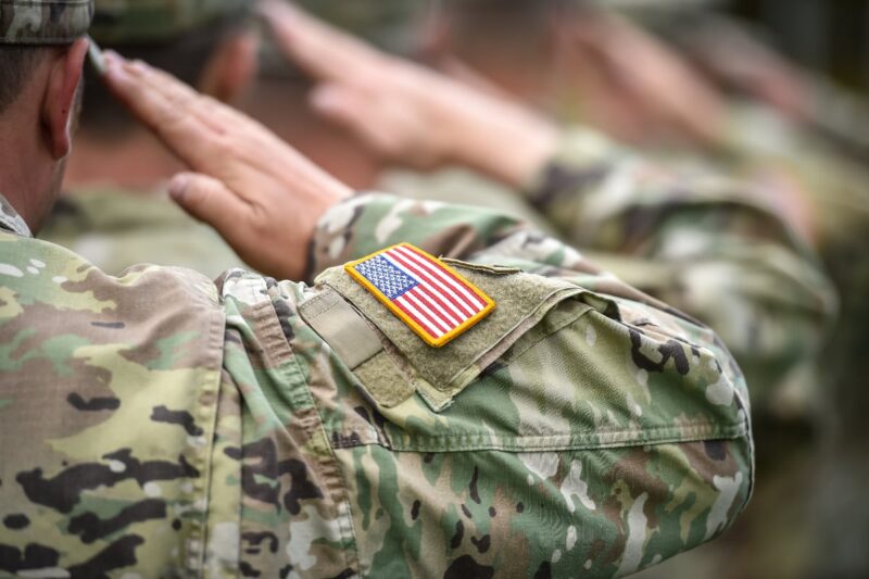 close up of a line of military personnel saluting